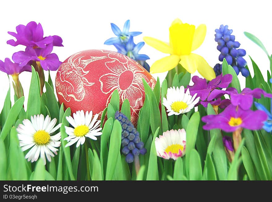 Traditional scratched hand-made Easter egg on a spring meadow