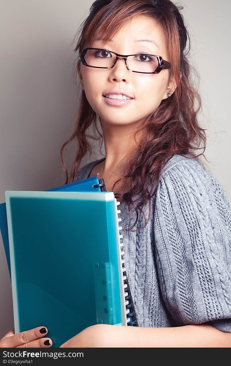 Asian girl holding a textbook. Wear glasses. Asian girl holding a textbook. Wear glasses.