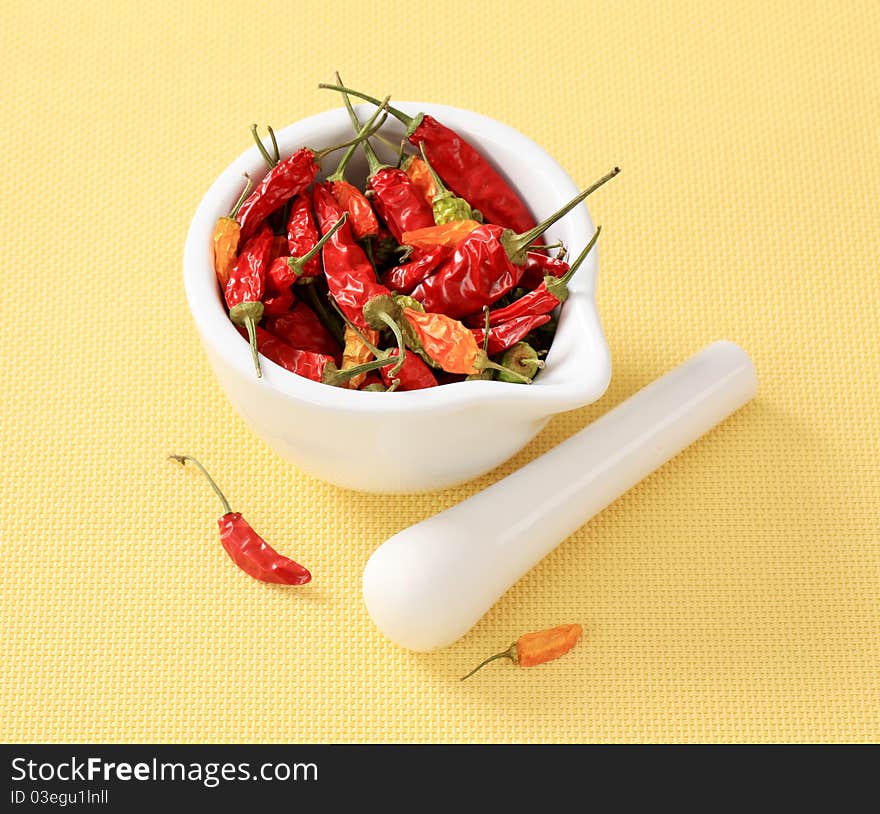 Dried chili peppers in a ceramic mortar