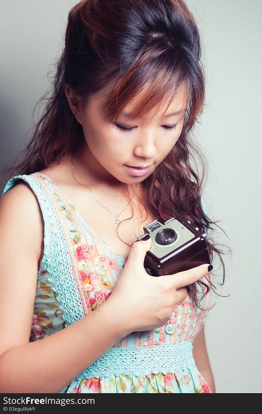 Portrait shot of a young woman holding a camera. Portrait shot of a young woman holding a camera.