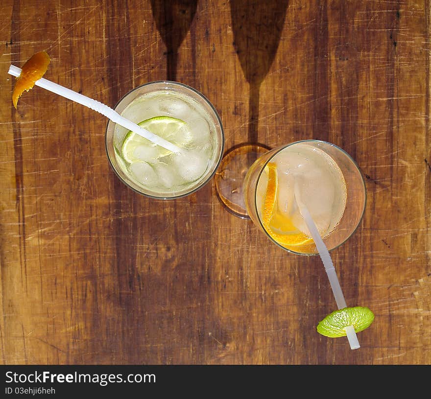 Two glasses with ice cubes, water and citrus