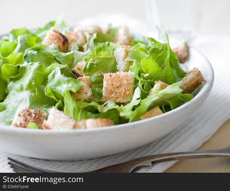 A bowl of fresh lettuce salad with crouton