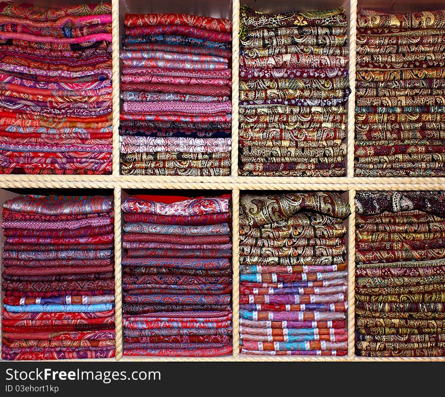 Big color palette spectrum of cotton and silk scarves on shelves front view. Big color palette spectrum of cotton and silk scarves on shelves front view