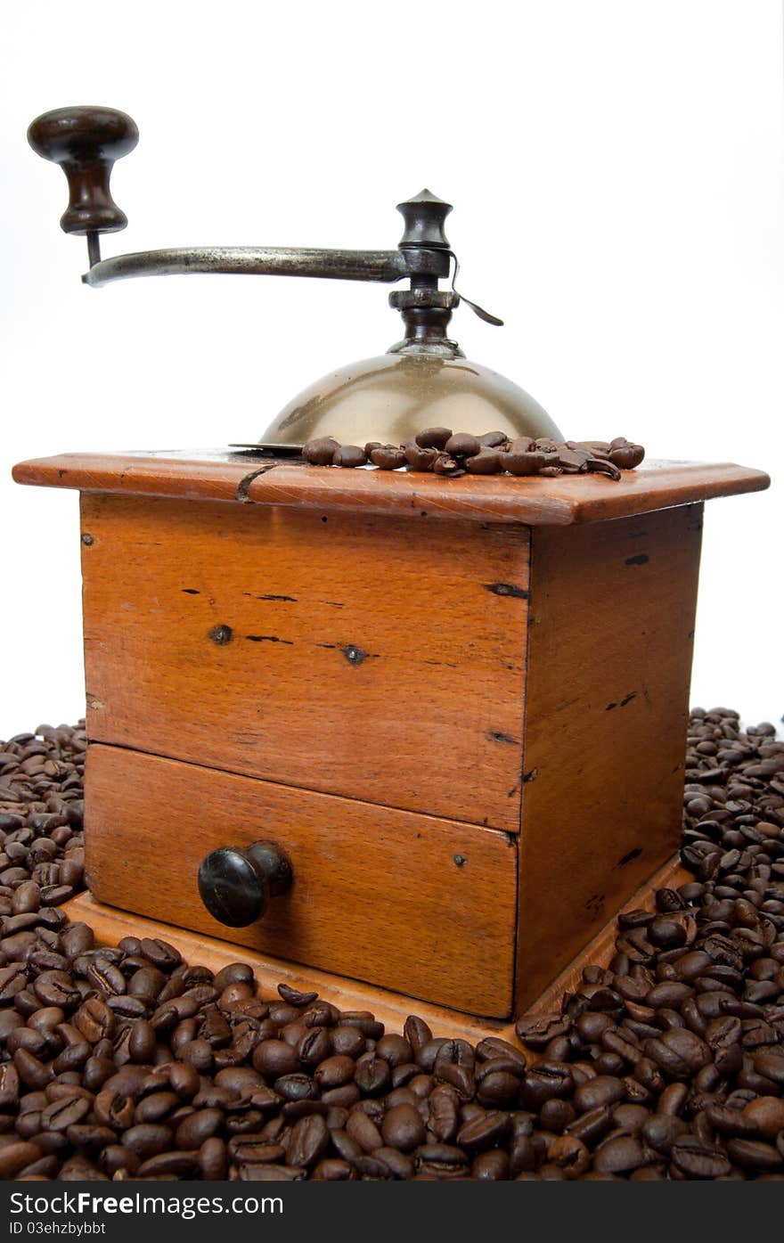 Old fashion coffee grinder against a white background with coffeebeans. Old fashion coffee grinder against a white background with coffeebeans