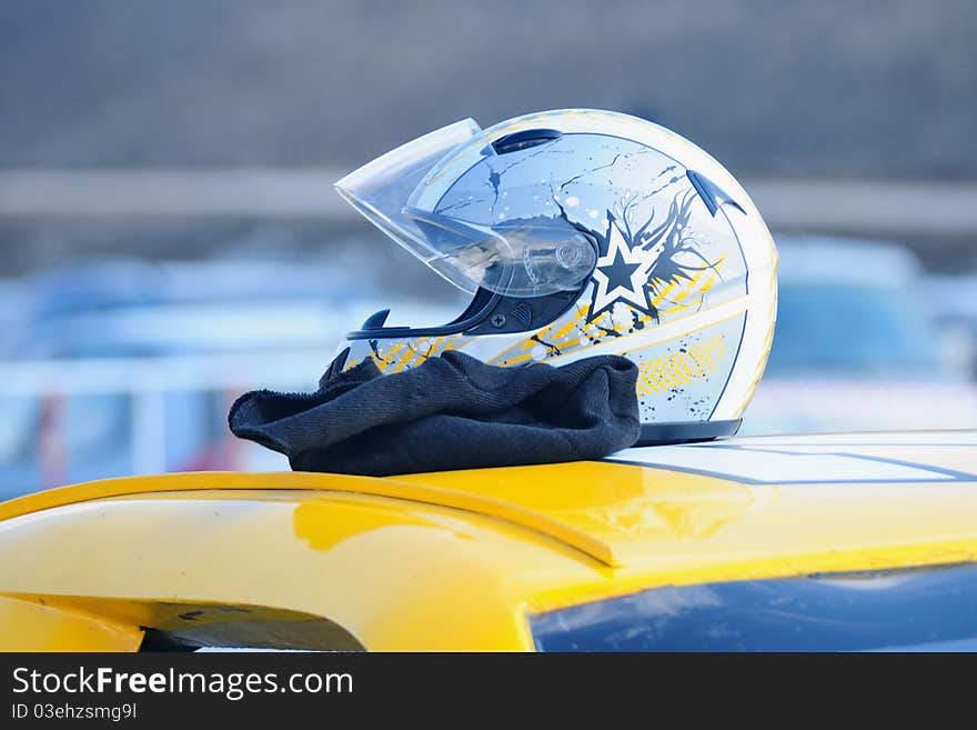 Helmet is lying on the roof of a car. Helmet is lying on the roof of a car