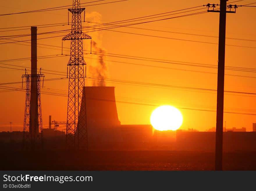 Solar disk above industrial landscape