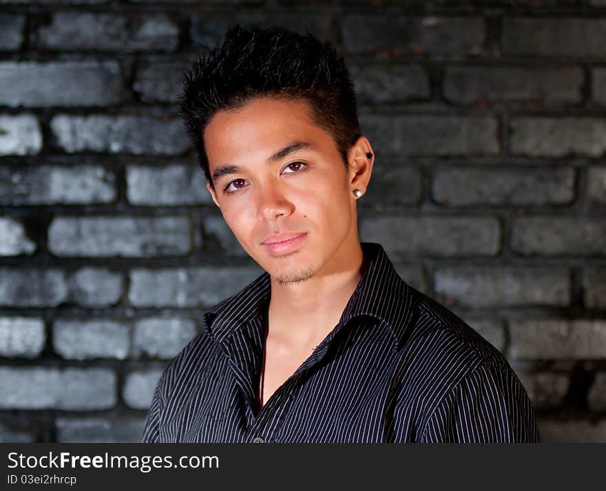 A nice image of a young man in front of a brick background. A nice image of a young man in front of a brick background.