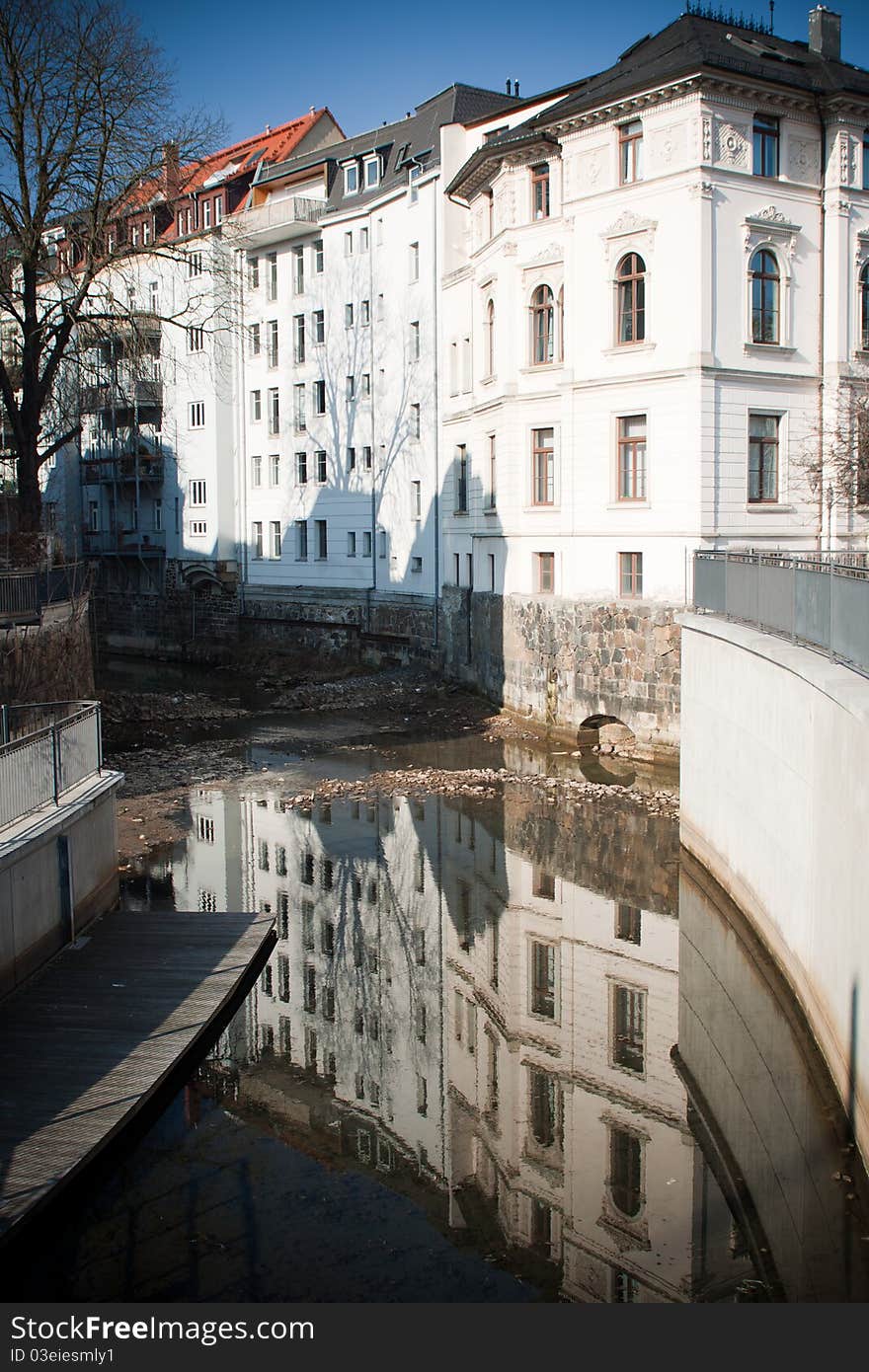 Old historical buildings in Leipzig are reflecting in water