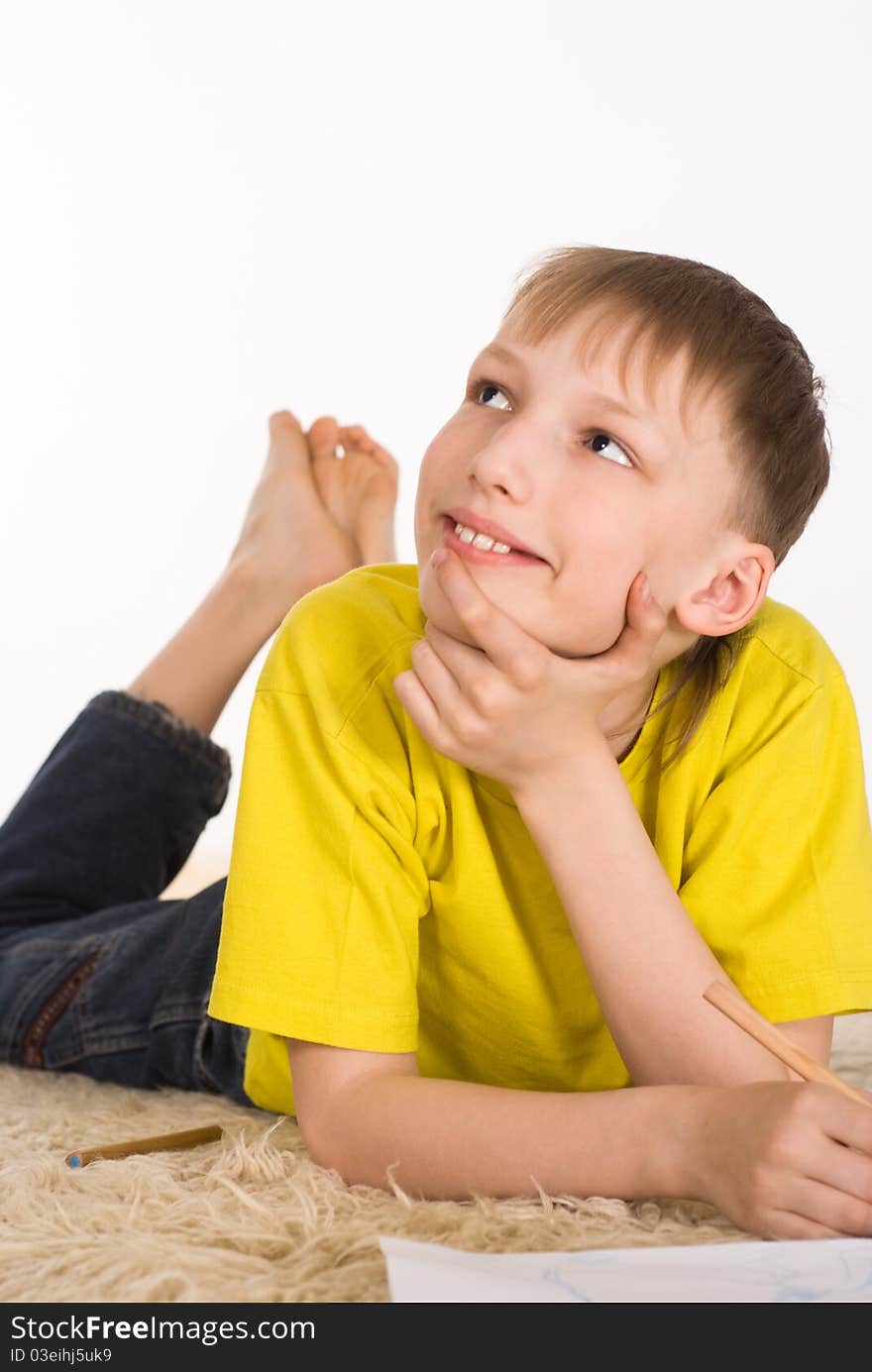 Young boy drawing on the carpet on white