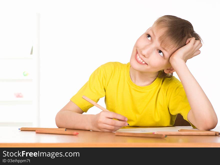 Young boy drawing at the table on white. Young boy drawing at the table on white