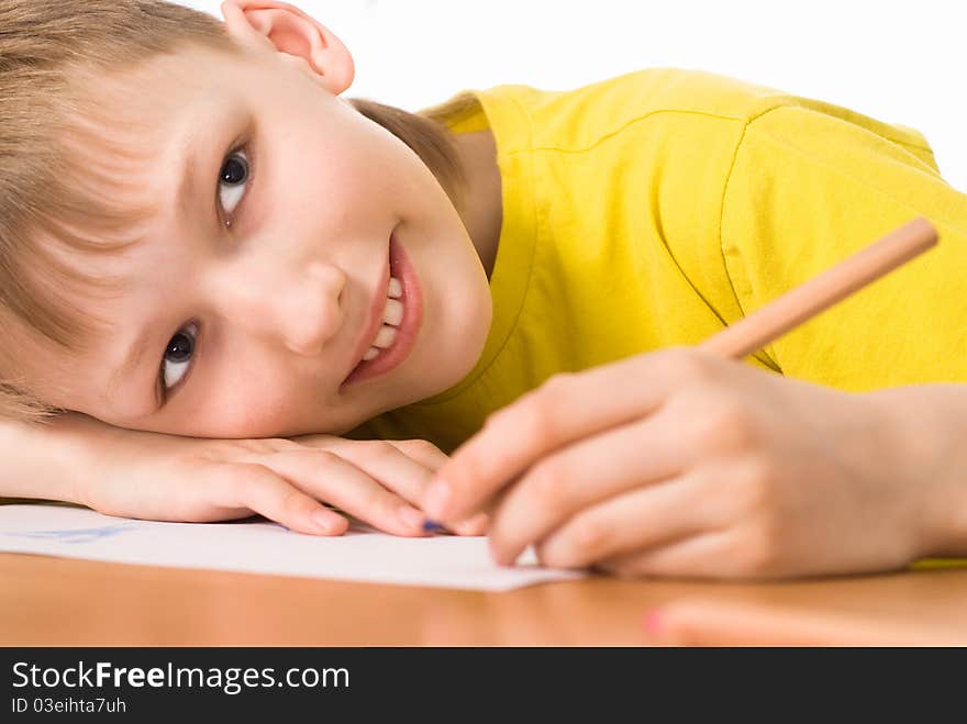 Young boy drawing at the table on white. Young boy drawing at the table on white