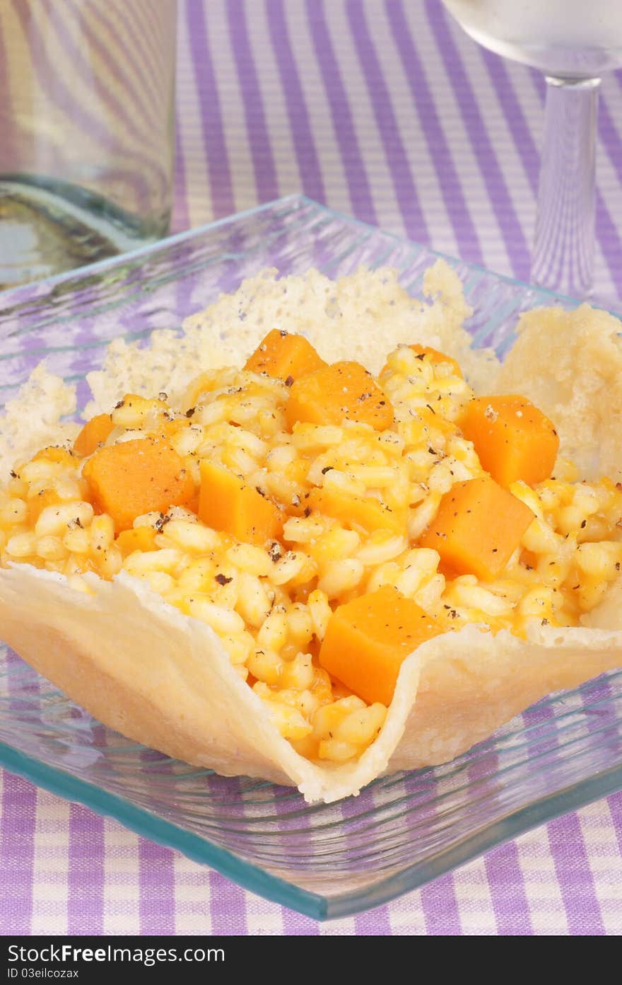 Cheese basket filled with risotto and pumpkin over a glass dish. Cheese basket filled with risotto and pumpkin over a glass dish.