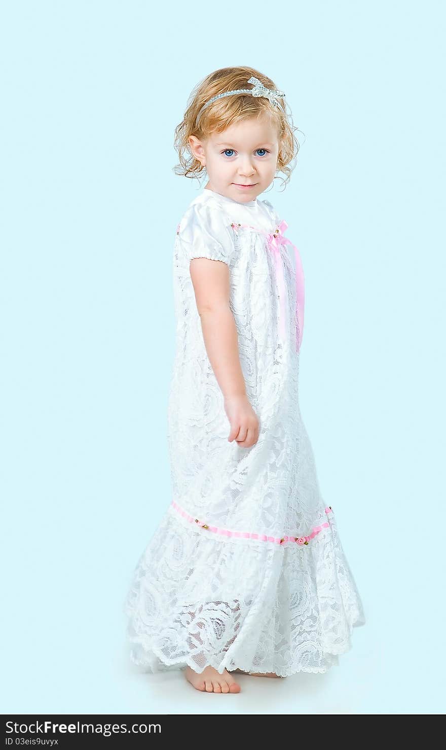 Portrait of pretty girl wearing traditional laced dress for first communion isolated on blue background. Portrait of pretty girl wearing traditional laced dress for first communion isolated on blue background