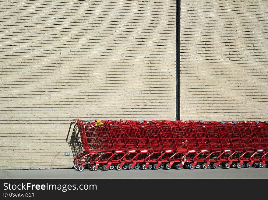 Shopping carts against a wall in the sun