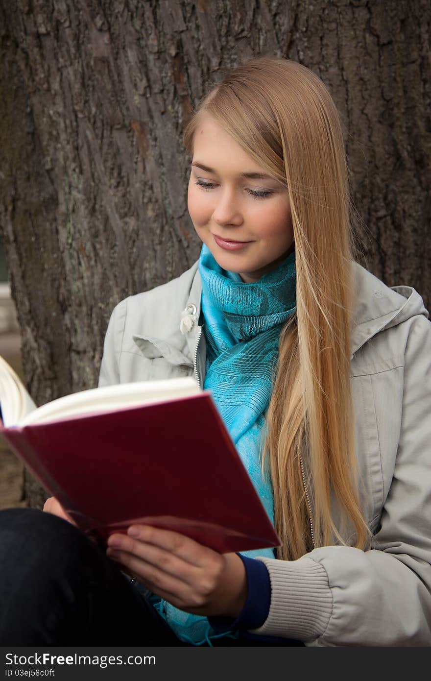 Girl reading a book in a park.