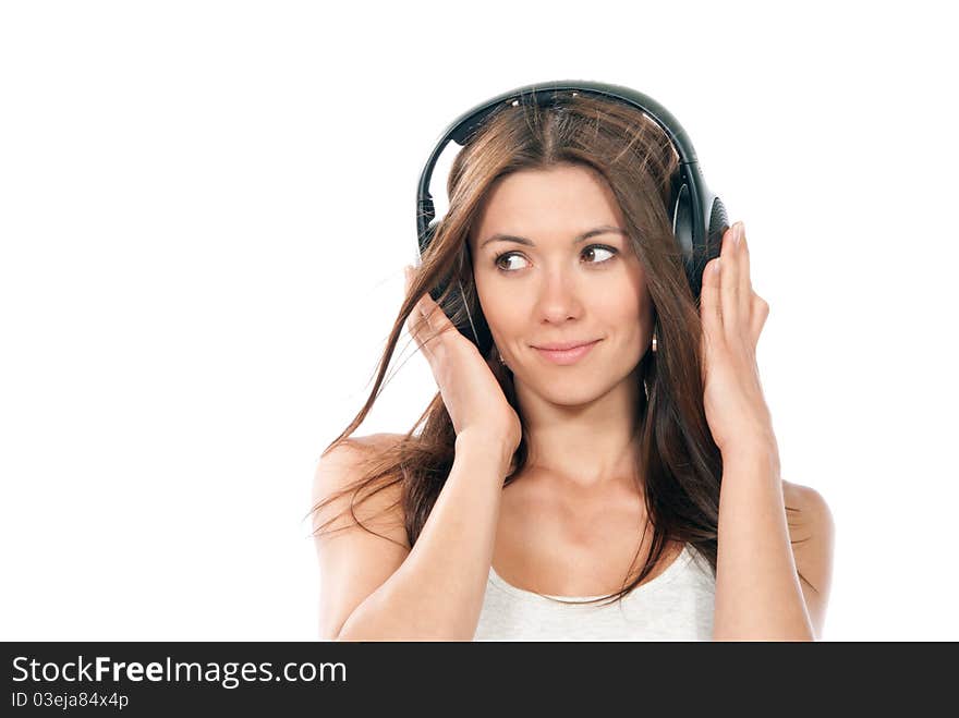 Happy brunette slim woman listening and enjoying music in headphones, smiling, laughing and not looking in camera isolated on a white background. Happy brunette slim woman listening and enjoying music in headphones, smiling, laughing and not looking in camera isolated on a white background