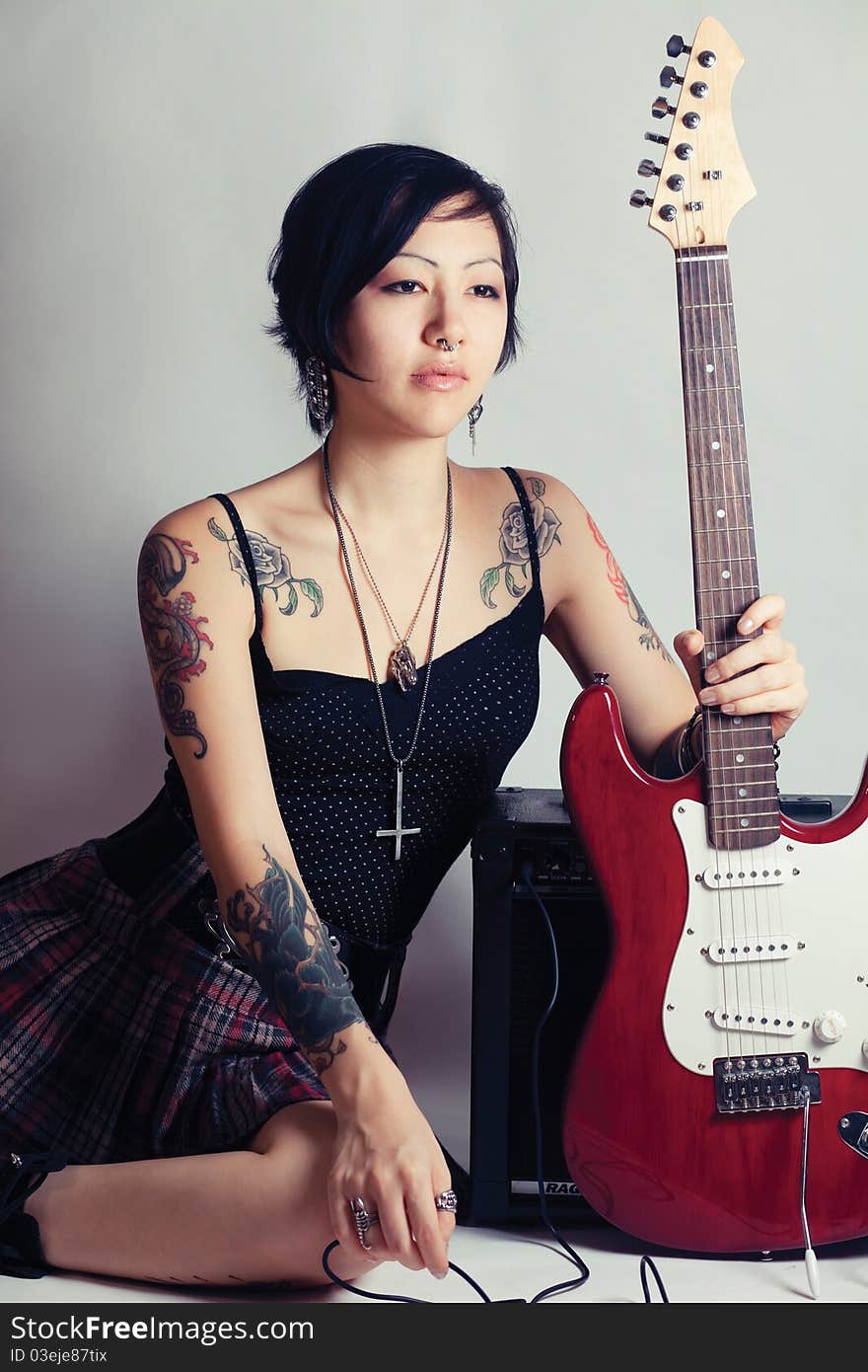 Funky young woman with her red hot guitar. Funky young woman with her red hot guitar.