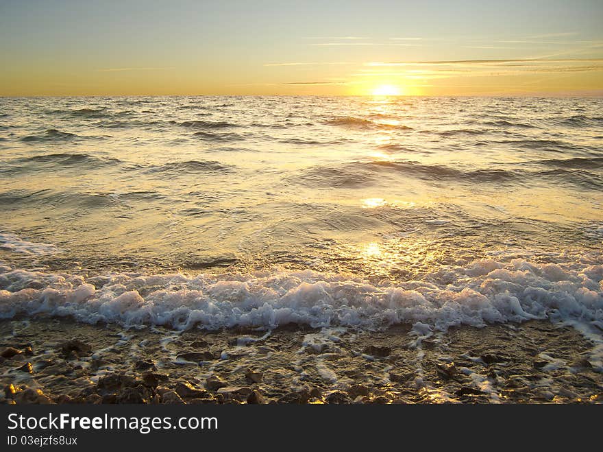 Golden sea sunset with braking waves