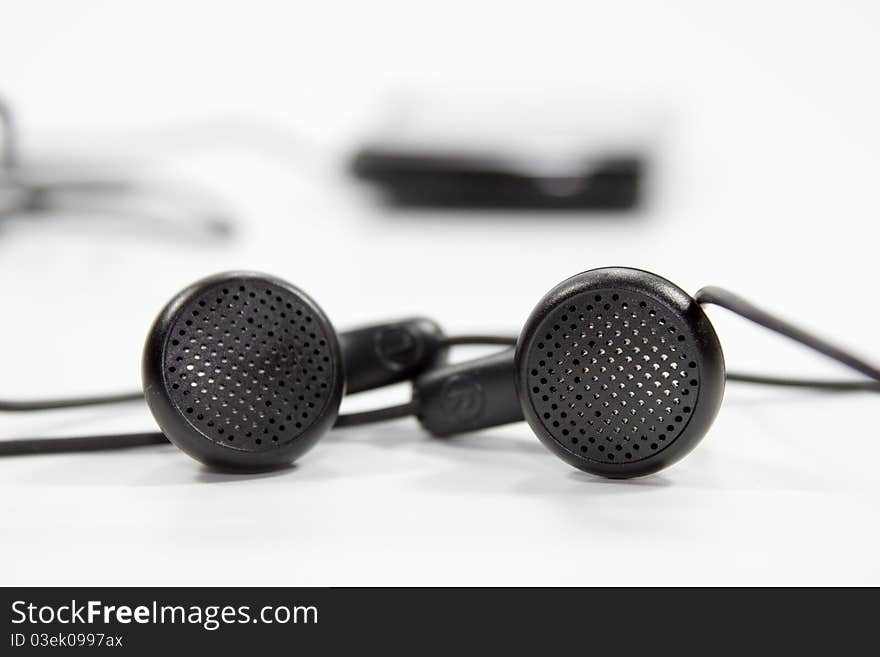 Black earphones on white background for music plying