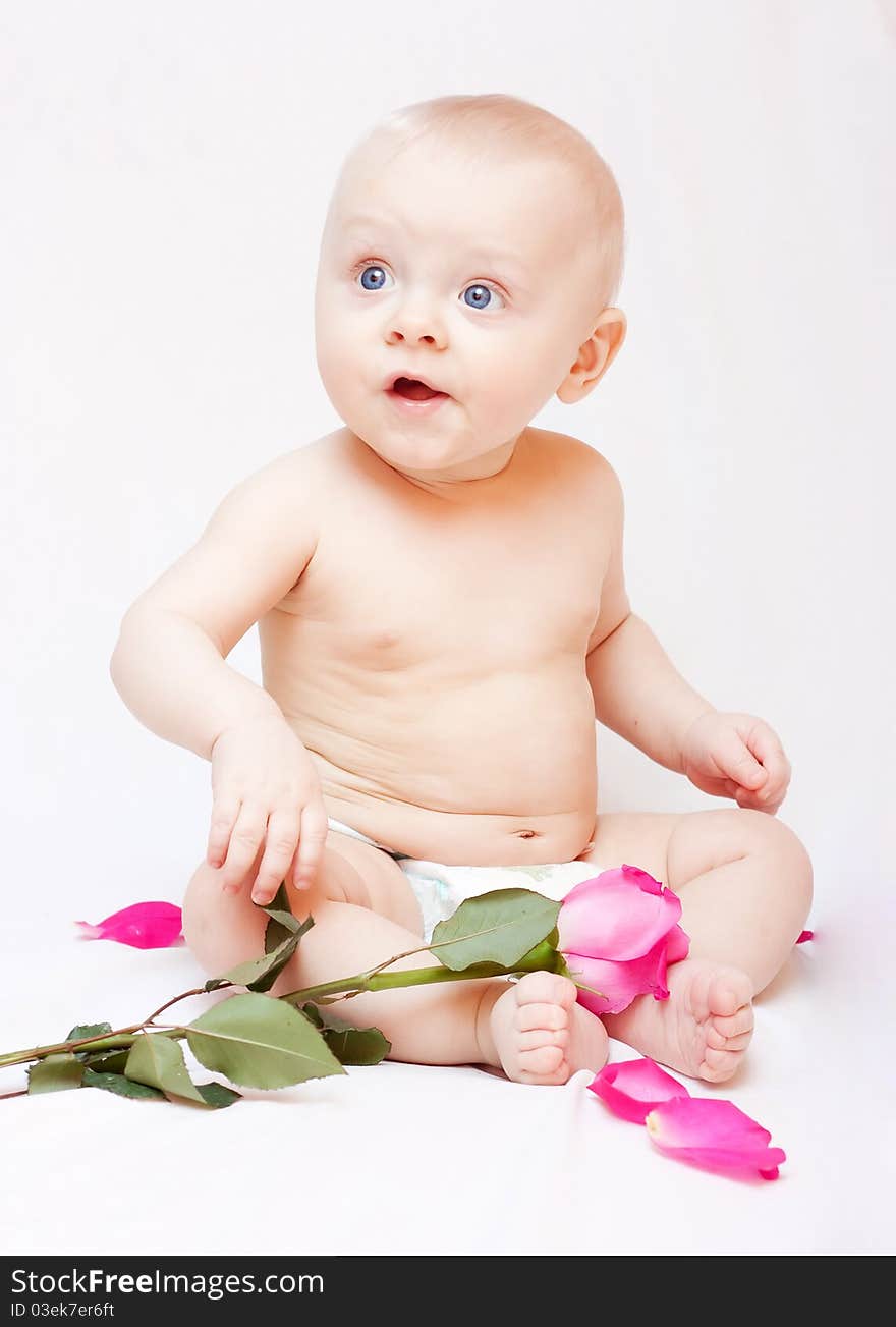 Newborn baby lying in a bed with pink roses. Newborn baby lying in a bed with pink roses