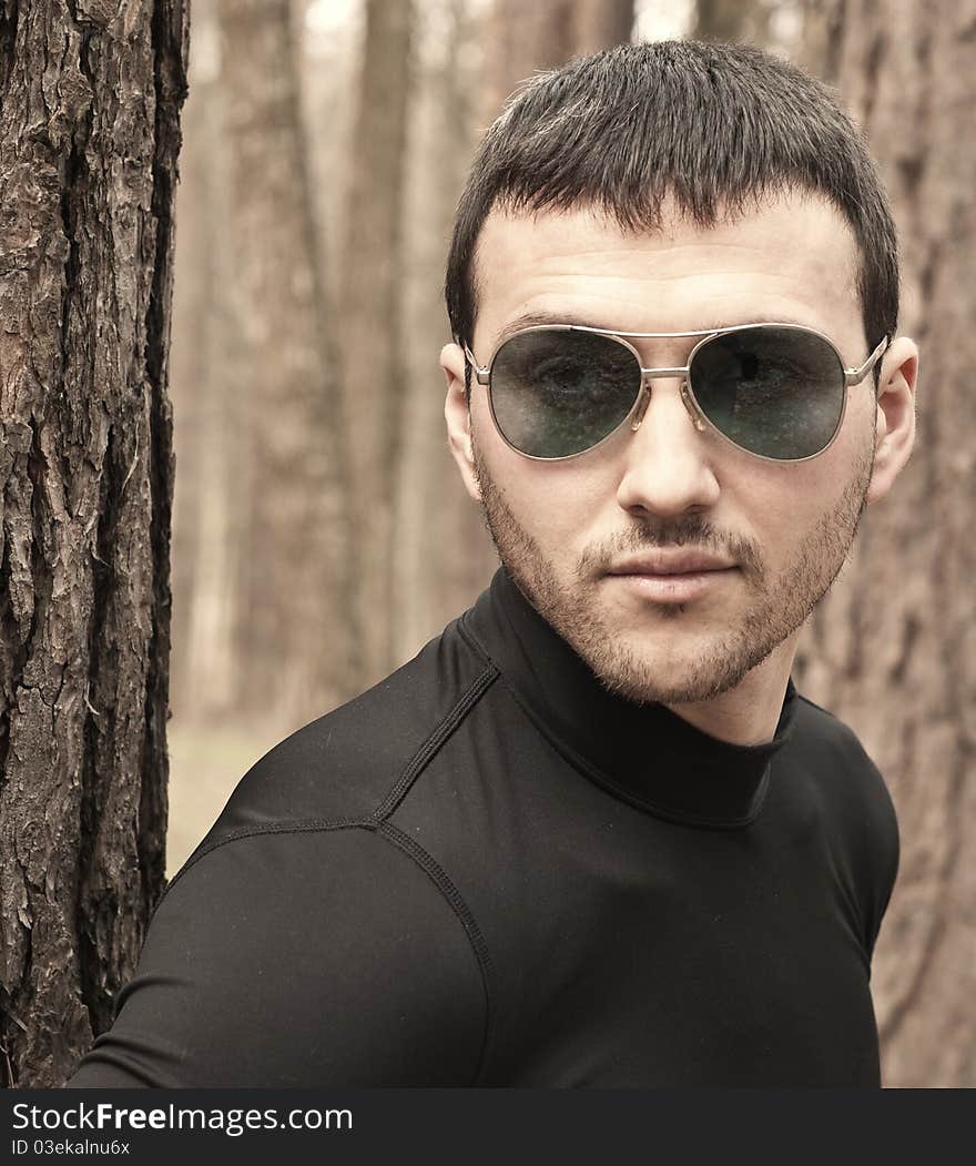 Young man in black clothes and sunglasses closeup portrait. Young man in black clothes and sunglasses closeup portrait