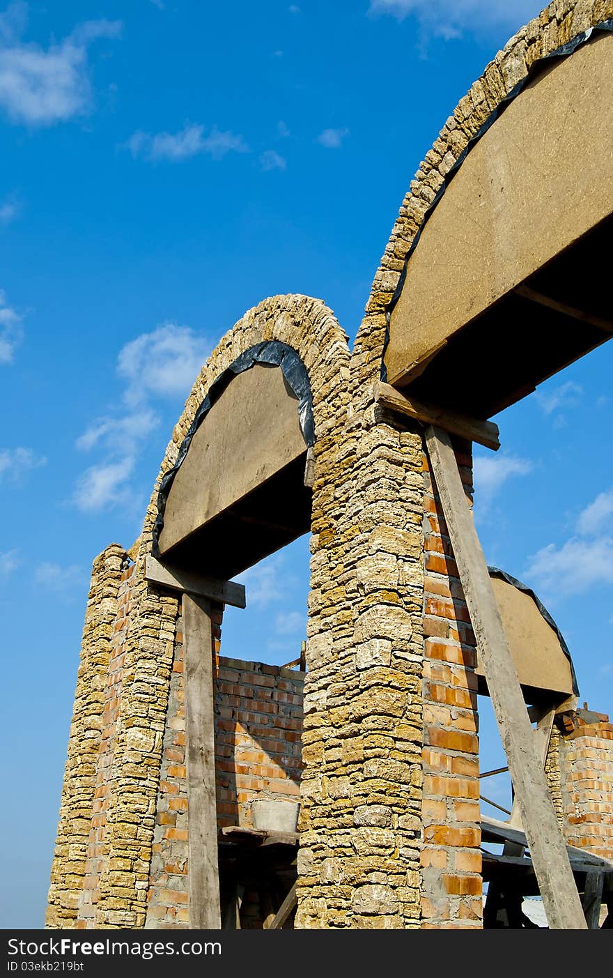 Erection of walls with arched window openings with natural stone. Erection of walls with arched window openings with natural stone.