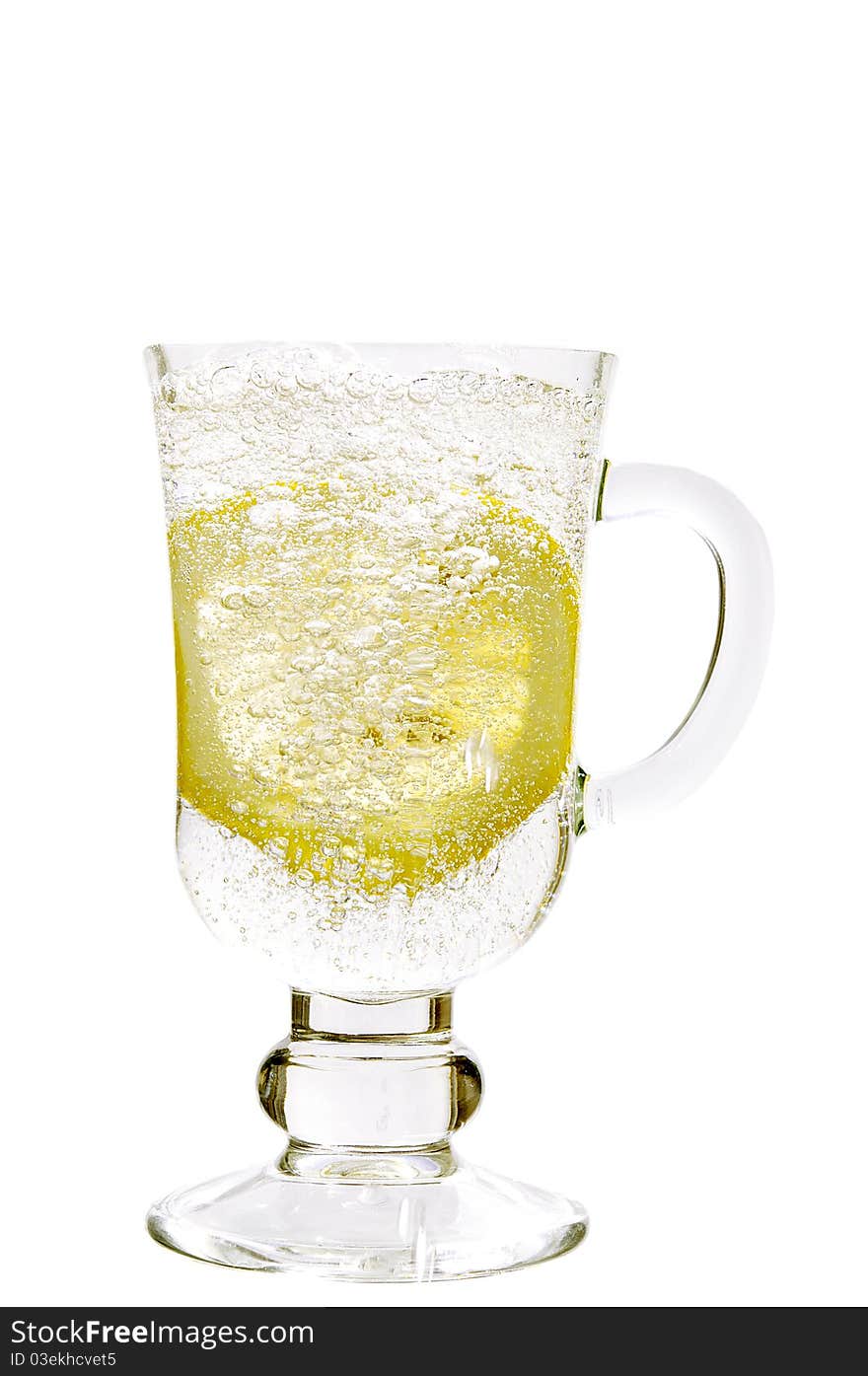 Mineral water in a glass with a lemon on the white isolated background