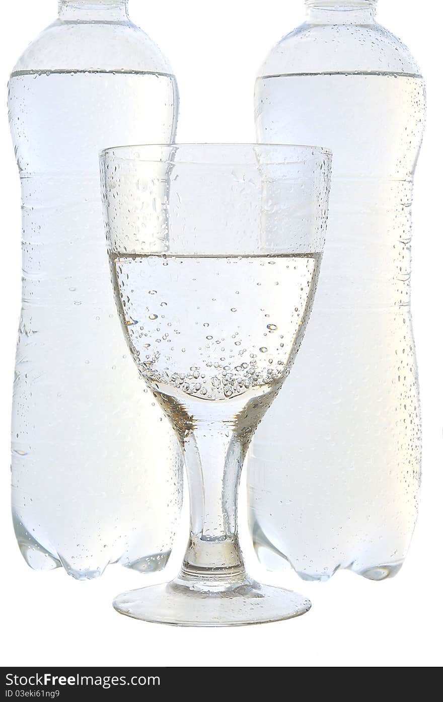 Mineral water in a glass and bottles