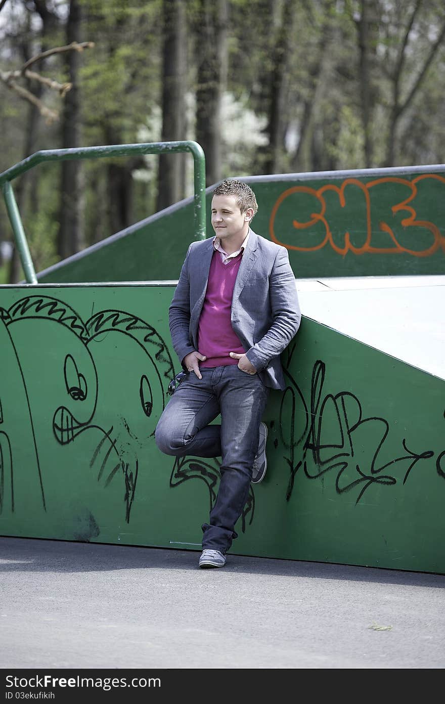 Young man posing in front of a colorful graffiti