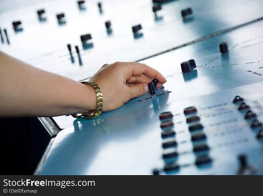 Woman's hands on the remote control in an industrial plant