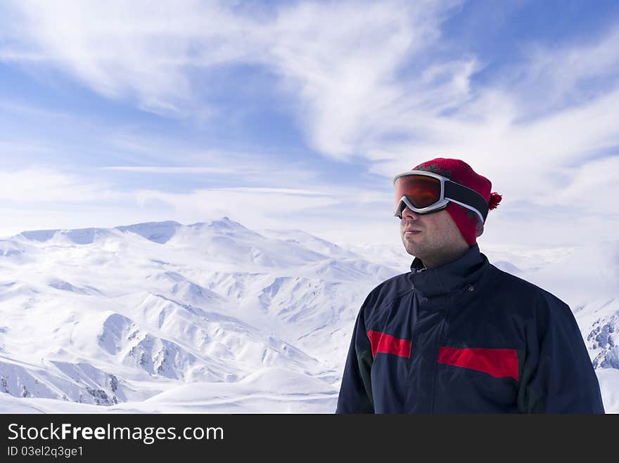 Young skier is looking on the mountain landscape