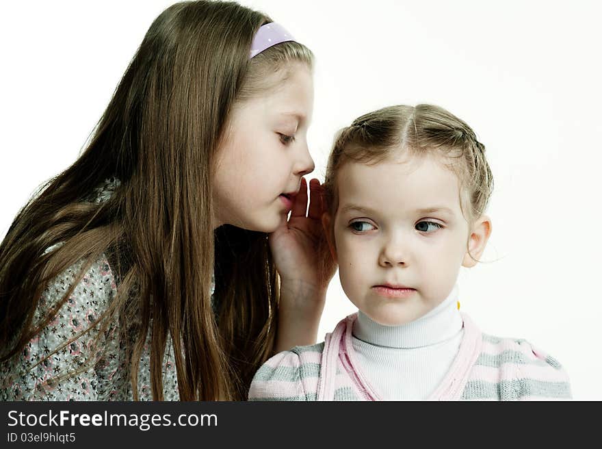 An image of a girl telling a secret to her sister