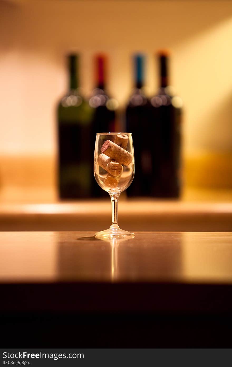 Wine glass with corks and wine bottles