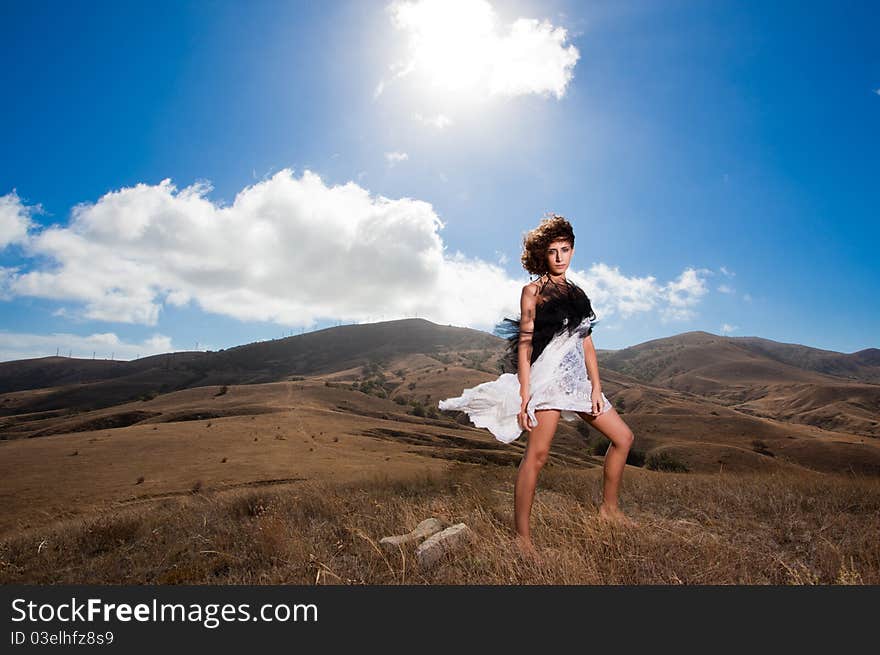 Beautiful curly woman pose in the mountains