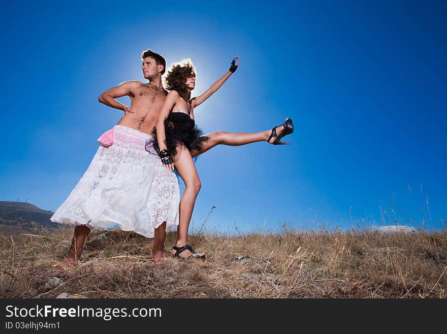 Fashion beautiful couple posing on summer mountains