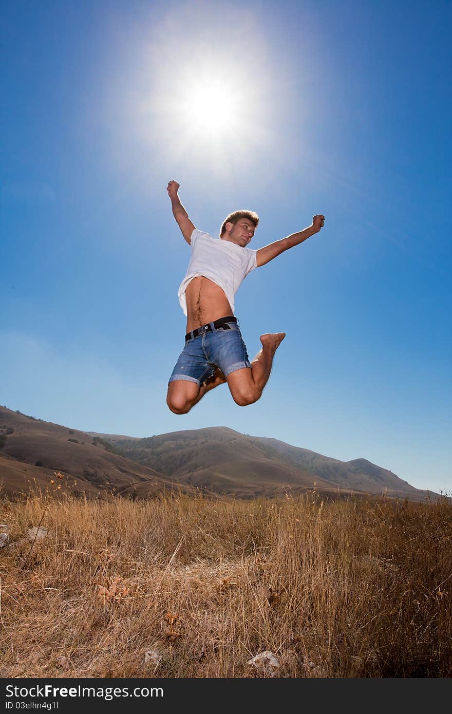 Happy young man jump in the summer mountains. Happy young man jump in the summer mountains