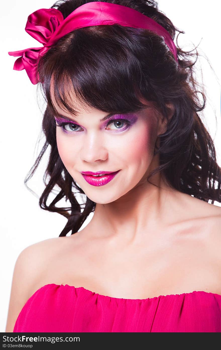 Portrait of beautiful girl with dark long curly hair and vibrant Make-up wearing pink satiny ribbon on white background. Portrait of beautiful girl with dark long curly hair and vibrant Make-up wearing pink satiny ribbon on white background