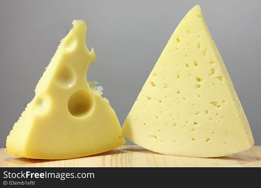 Two pieces of cheese on the kitchen table.