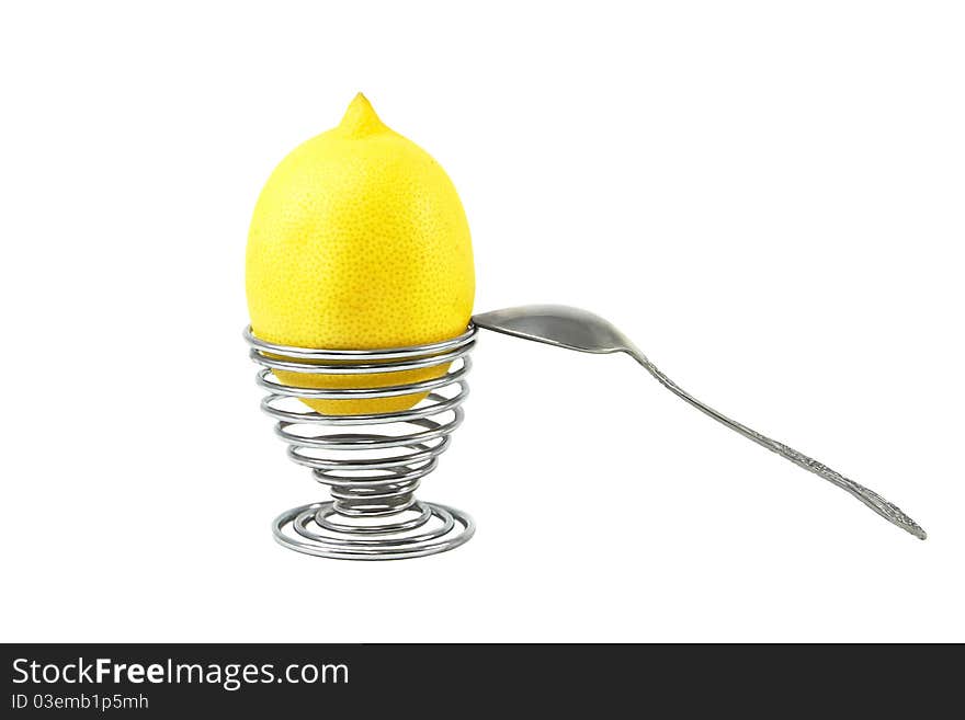 Lemon in the eggcup with spoon on the white background. Lemon in the eggcup with spoon on the white background