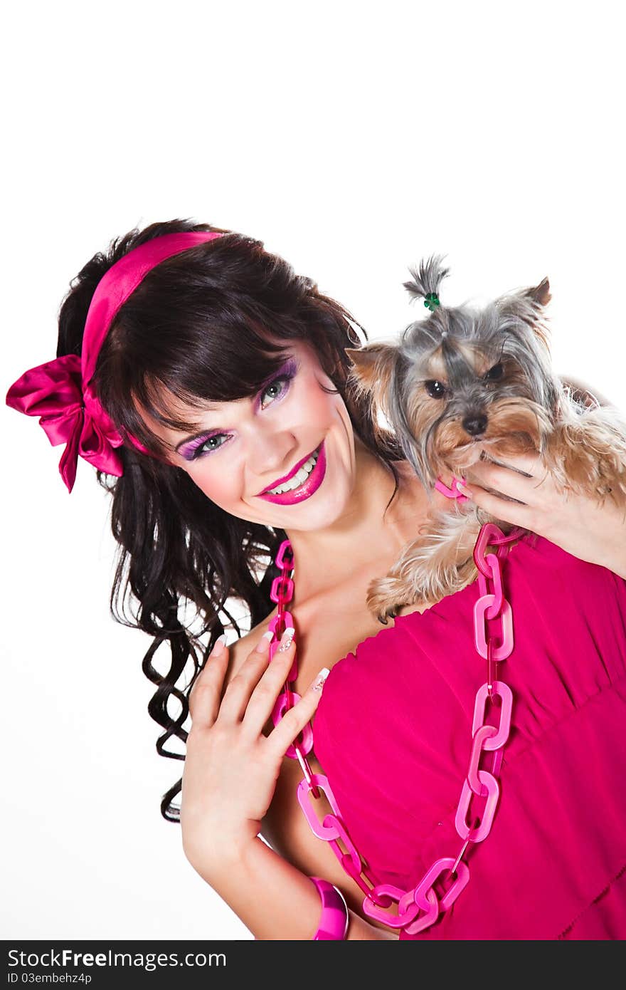 Portrait of beautiful girl with dark long curly hair and vibrant make-up wearing pink satiny ribbon holding small dog on white background. Portrait of beautiful girl with dark long curly hair and vibrant make-up wearing pink satiny ribbon holding small dog on white background