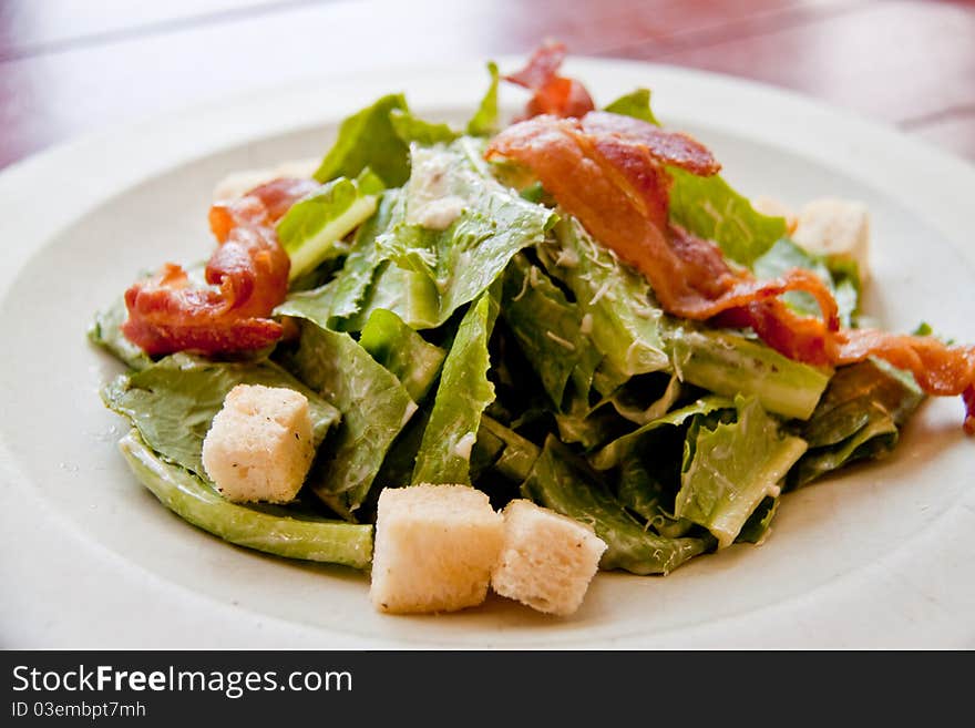 Bacon salad in the white plate