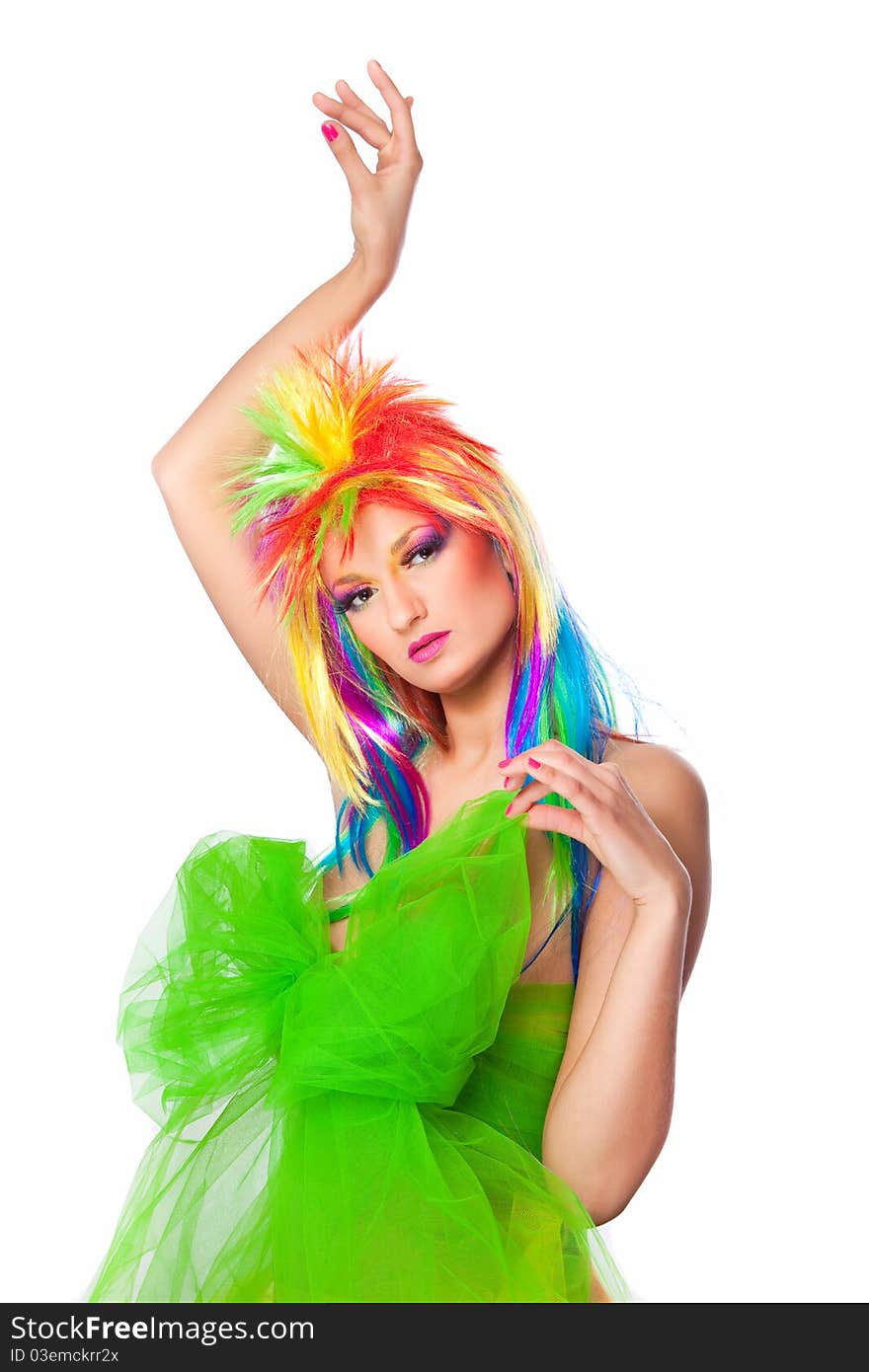 Beautiful girl with vibrant make-up wearing multicolored wig and creative dress with big green bow posing in dance. Beautiful girl with vibrant make-up wearing multicolored wig and creative dress with big green bow posing in dance