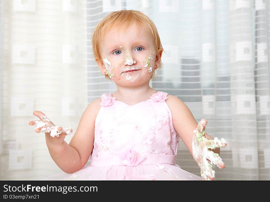 Girl enjoying her first birthday cake. Girl enjoying her first birthday cake