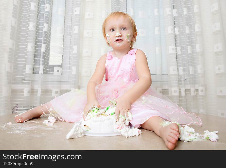 Girl enjoying her first birthday cake. Girl enjoying her first birthday cake