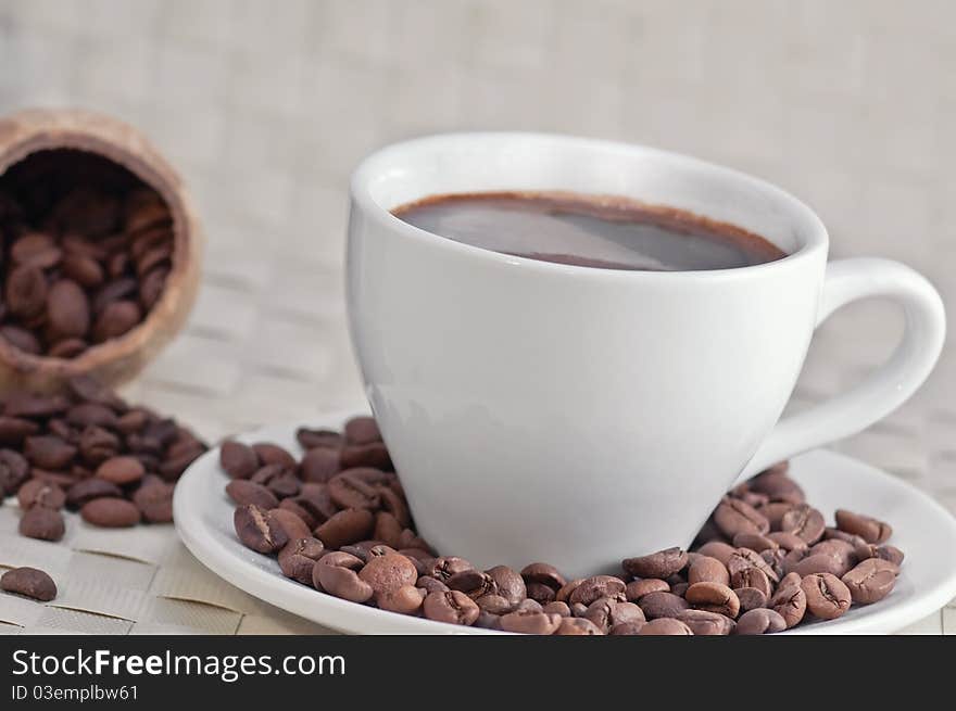 Coffee cup with roasted coffee beans, close-up