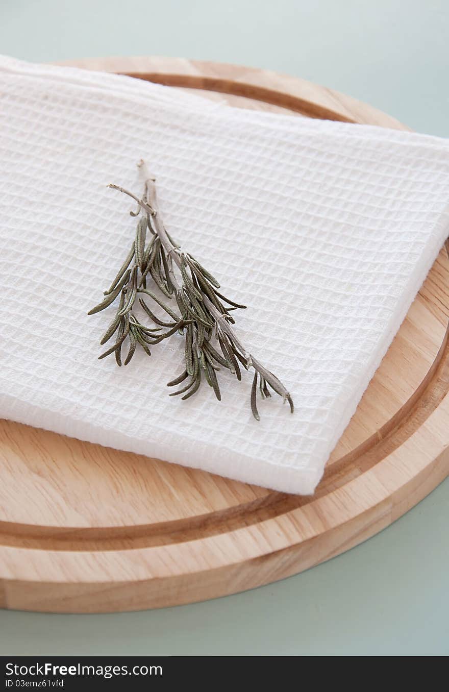 Rosemary on the white towel and round breadboard