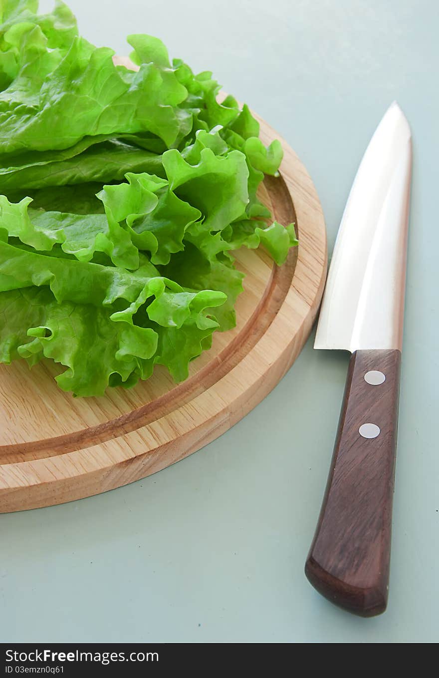 Fresh green salad on the breadboard with knife. Fresh green salad on the breadboard with knife