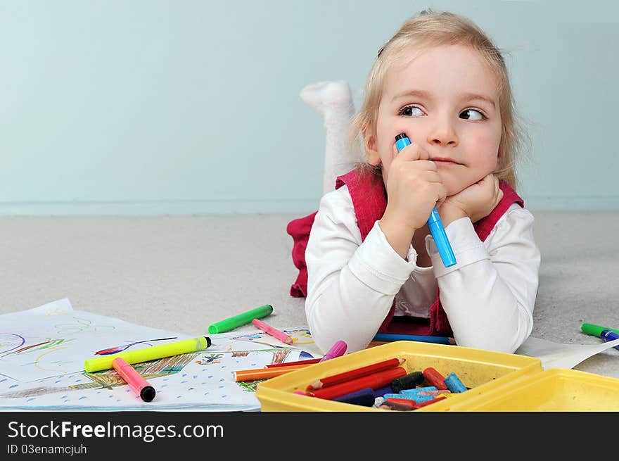 Beautiful little girl is drawing on paper