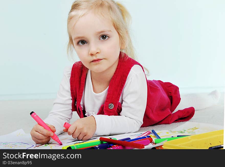 Beautiful little girl is drawing on paper