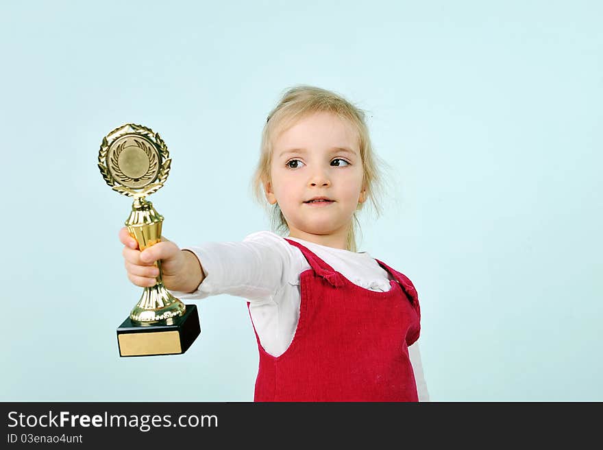 Lovely blond little girl with champion cup